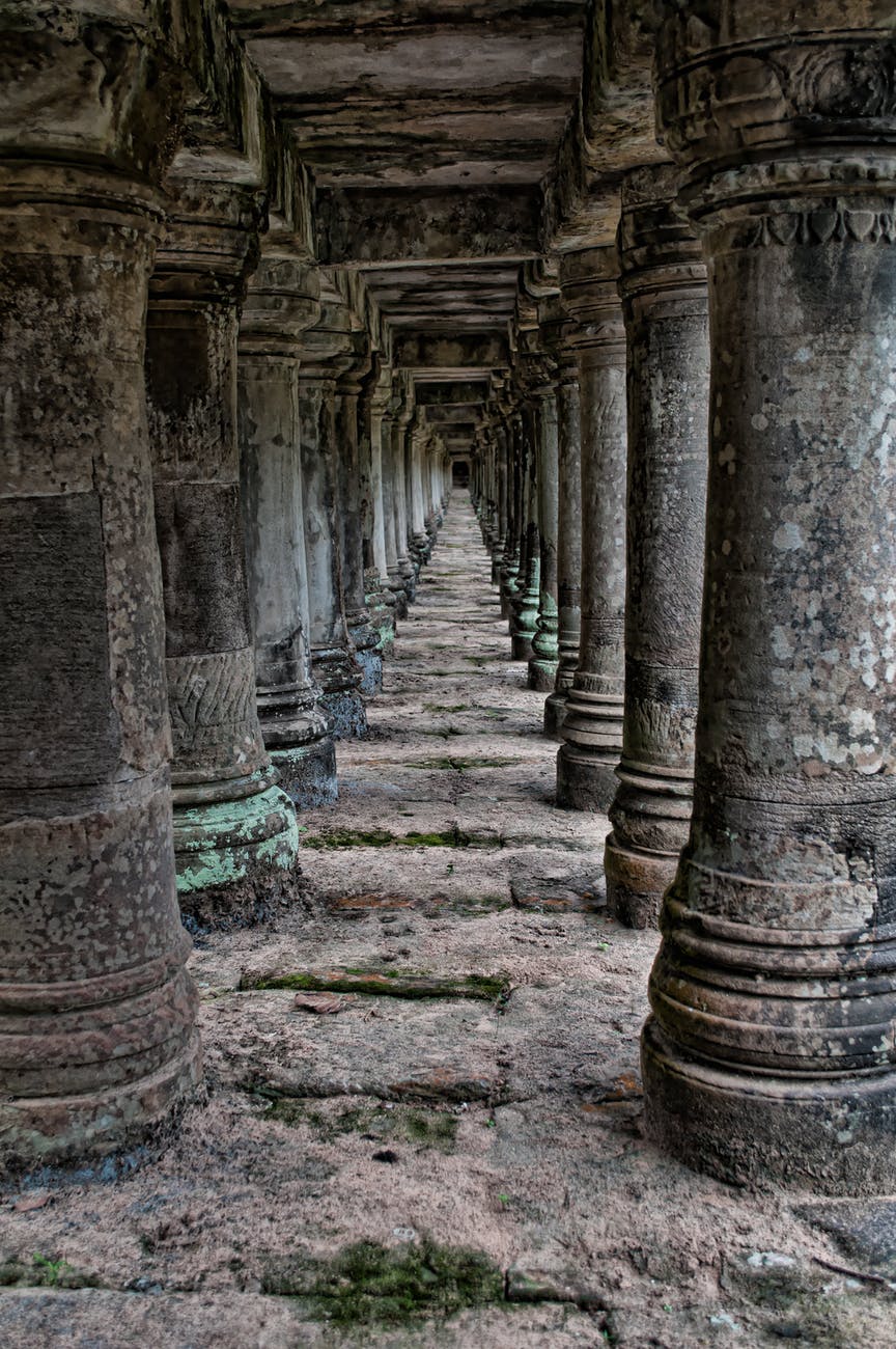 a photo showing a crumbling gray concrete tunnel of pillars