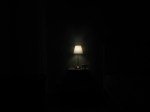 A small, dim lamp in a nearly pitch-black room